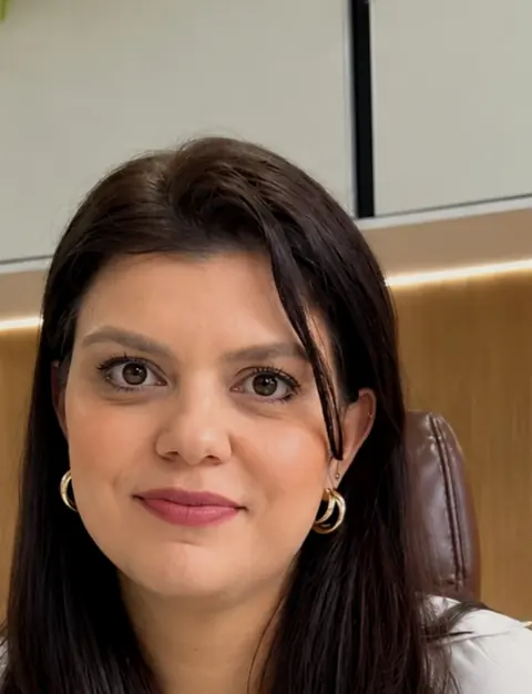 Dra. Giulia B. Fenili, ginecologista e obstetra, sorrindo no consultório